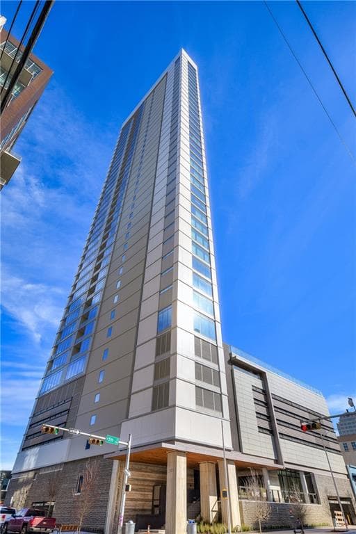 The triangular Fifth & West Residences tower rising against a clear sky
